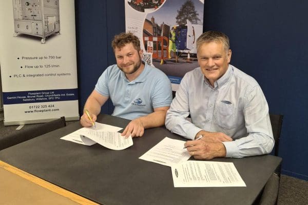 Two people signing contracts