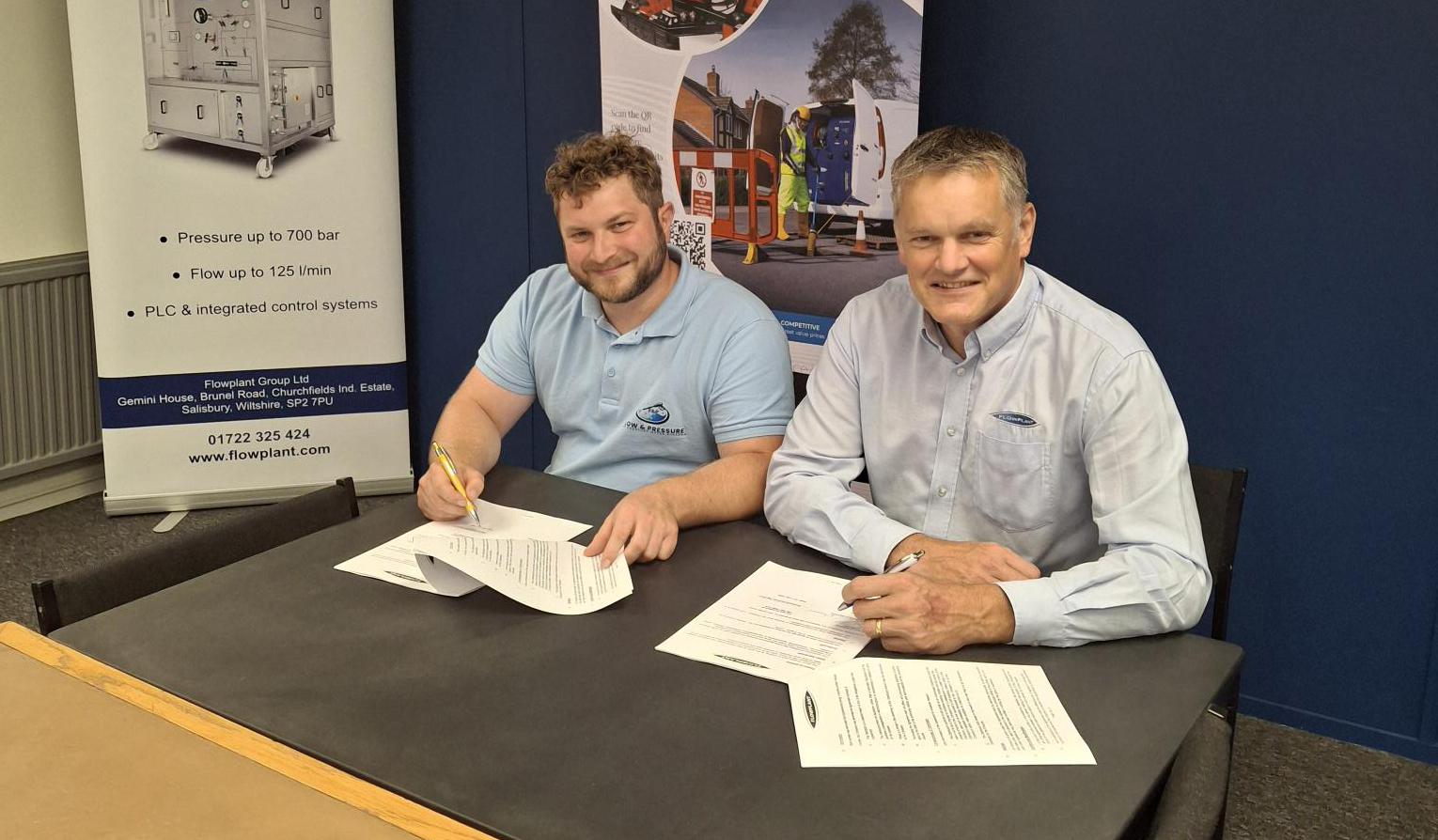 Two people signing contracts